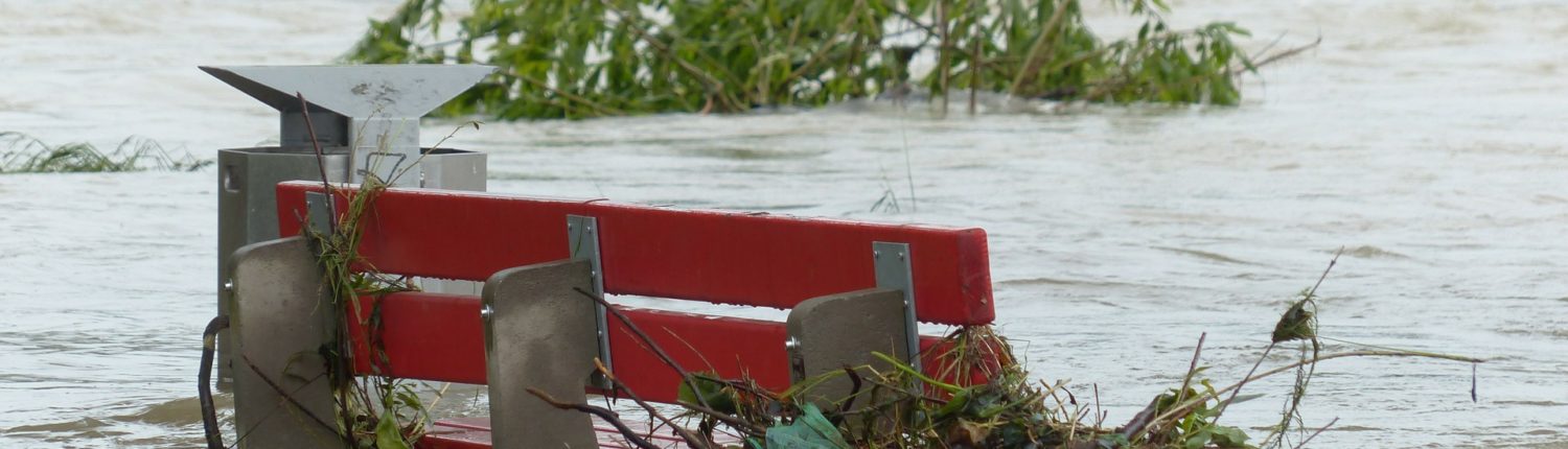 Image of flooded red park bench.